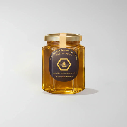 Pot Twentse bijenhoning met goudkleurig deksel, label en heldere honing op witte achtergrond